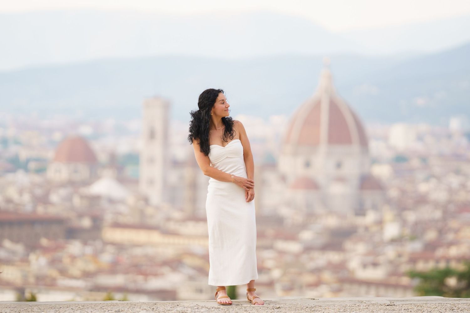 A scenic view of Florence, Italy cityscape with the iconic Duomo cathedral dome rising above terracotta rooftops.