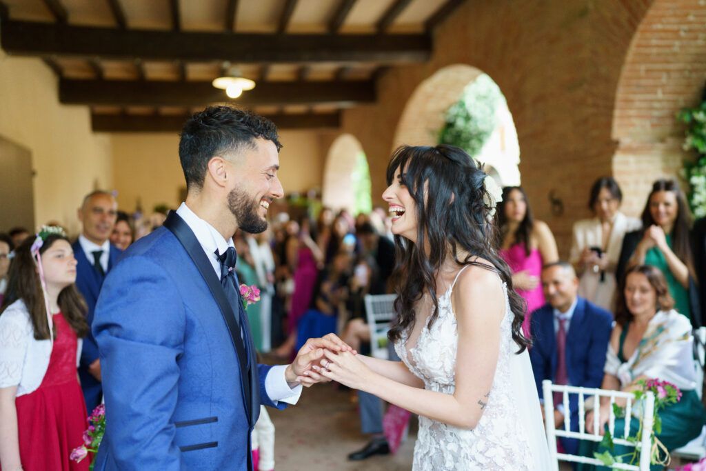 Wedding guests celebrate in a rustic venue with exposed brick walls and wooden beams.