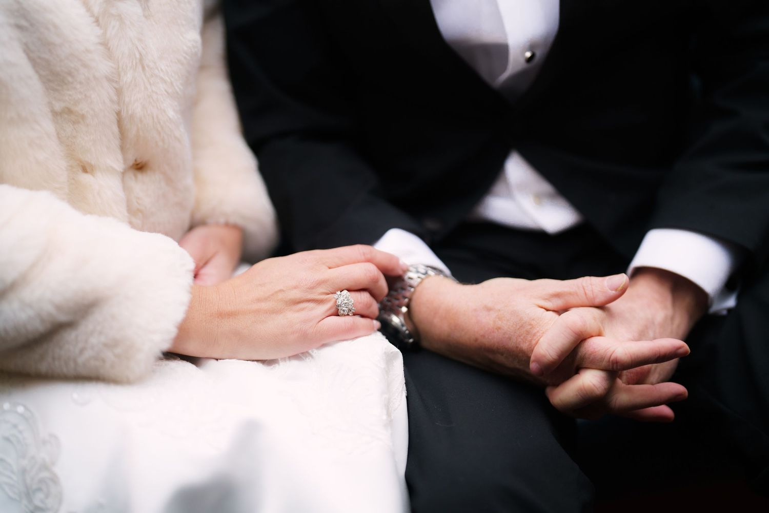 Close-up sequence of hands exchanging wedding rings during a traditional marriage ceremony.
