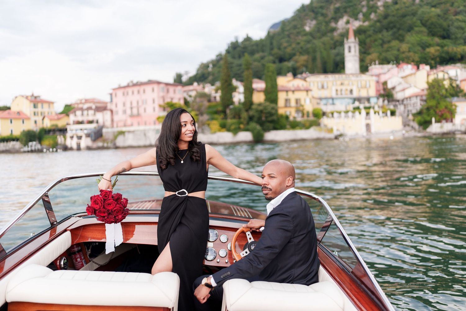 Guests enjoy a scenic boat ride along the waterfront of an Italian coastal town with historic buildings in view.