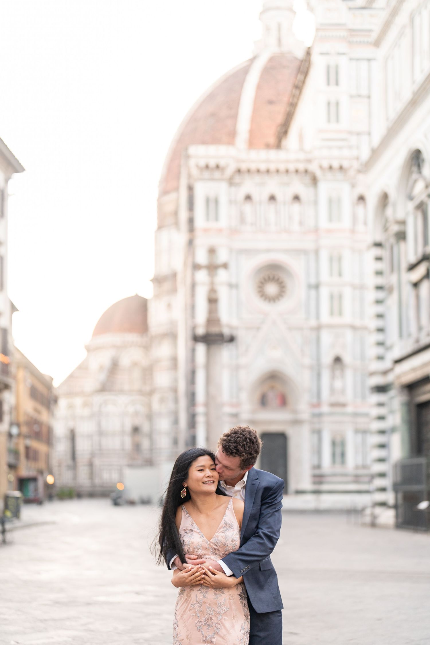 A romantic couple shares intimate moments in front of Florence's Duomo cathedral in Italy during a photo session.
