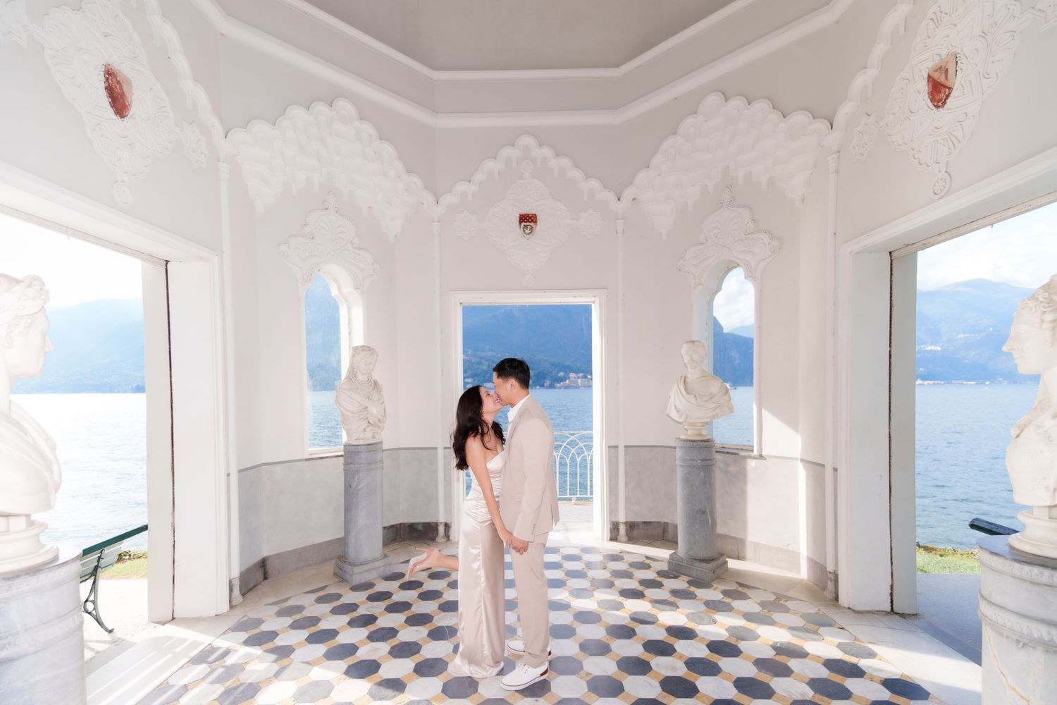 A bright white room with checkered floors and floating pink and white balloons creates a dreamy atmosphere.