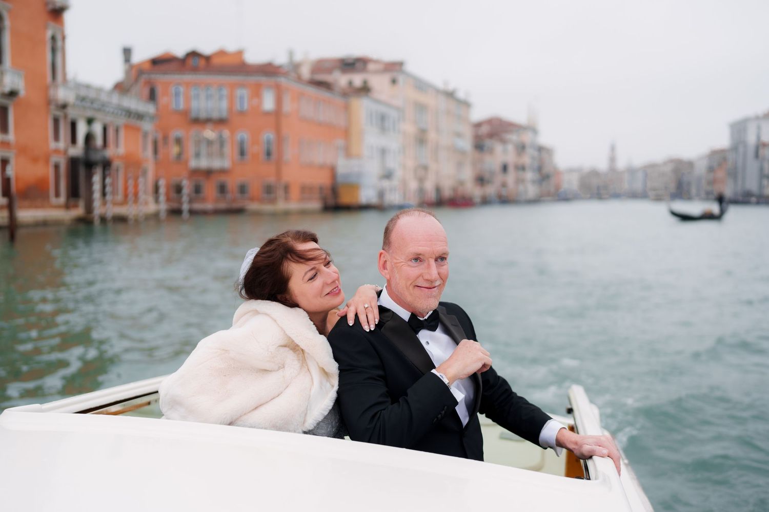 Romantic wedding couple sharing intimate moments while riding in a gondola along Venice's scenic canals.