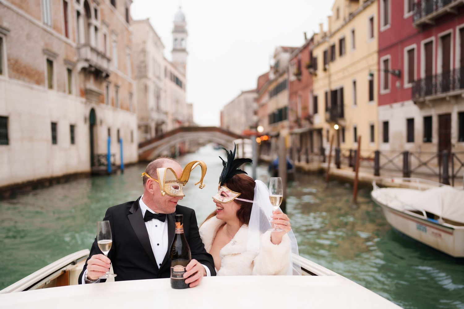 A romantic couple embraces while riding in a traditional wooden gondola through the scenic canals of Venice, Italy.