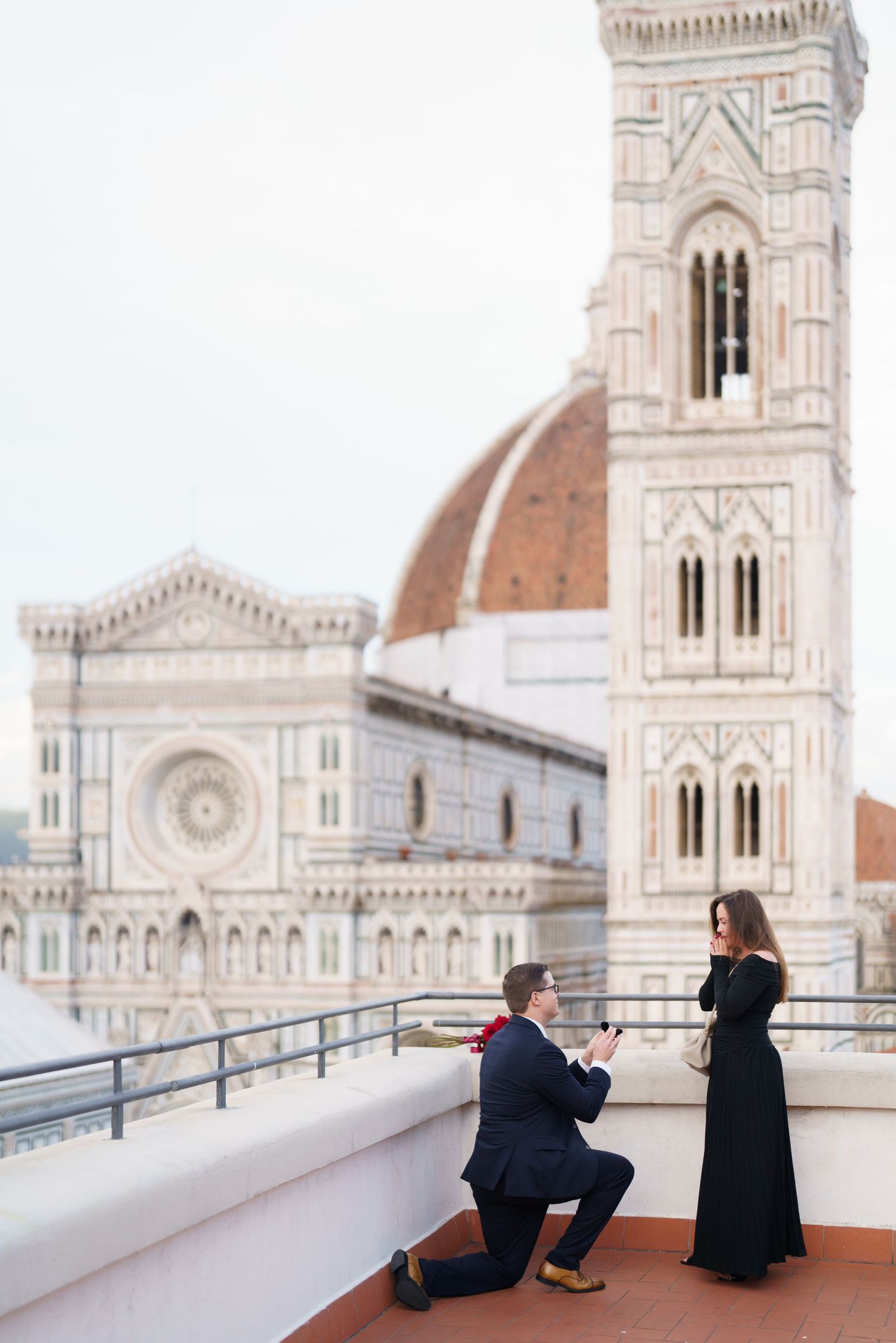 Two people sit on a terrace overlooking the historic Florence Cathedral and its iconic dome in Italy.