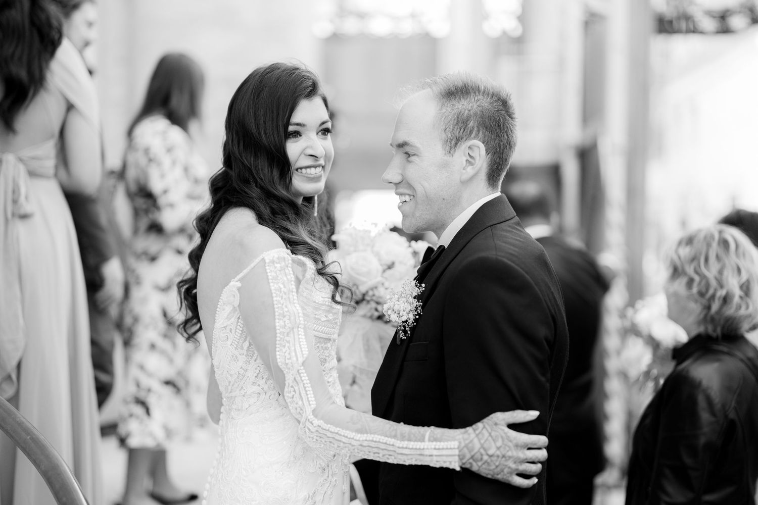 A black and white candid moment during an indoor wedding celebration.