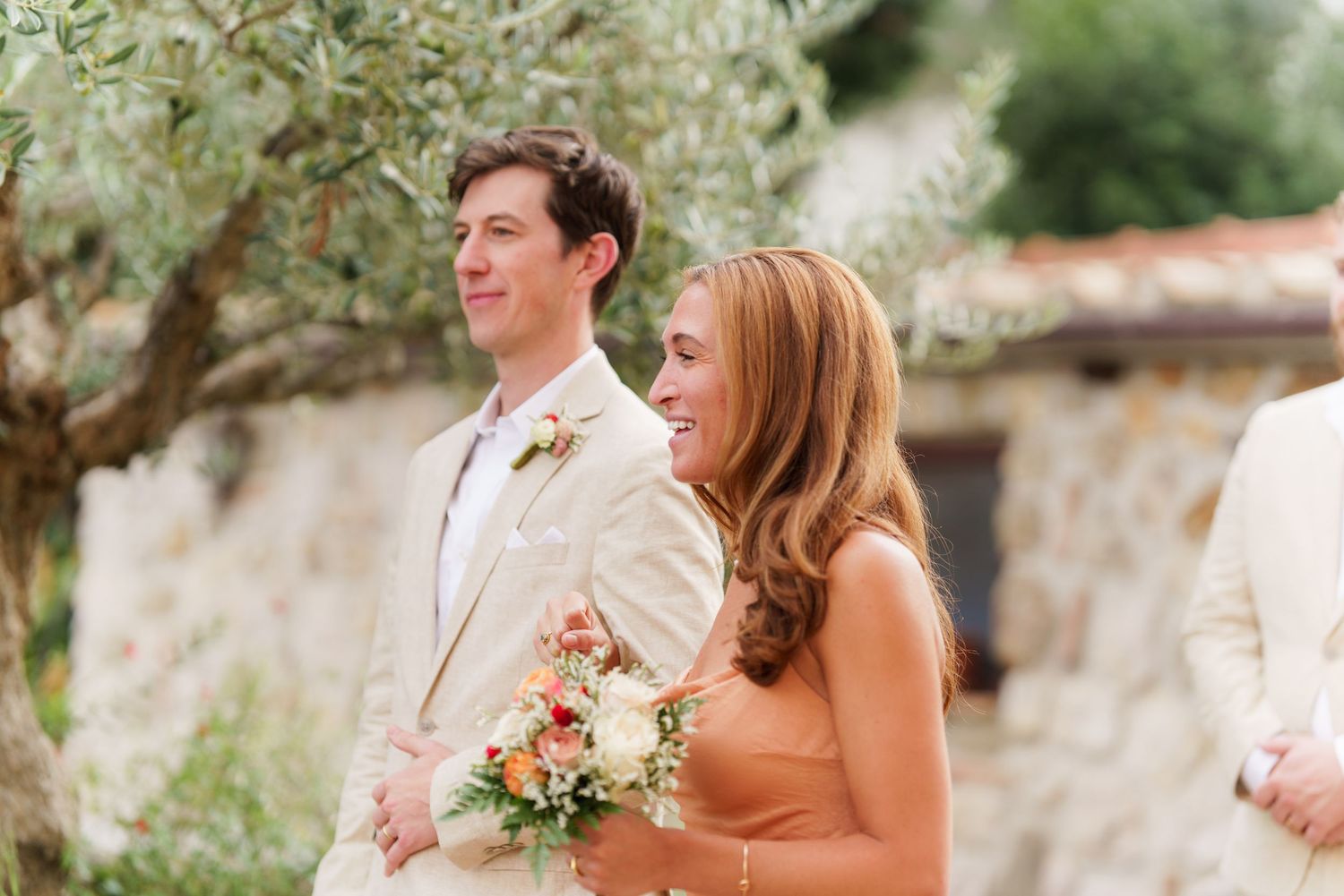 Candid moments captured between wedding party members in an outdoor garden setting.