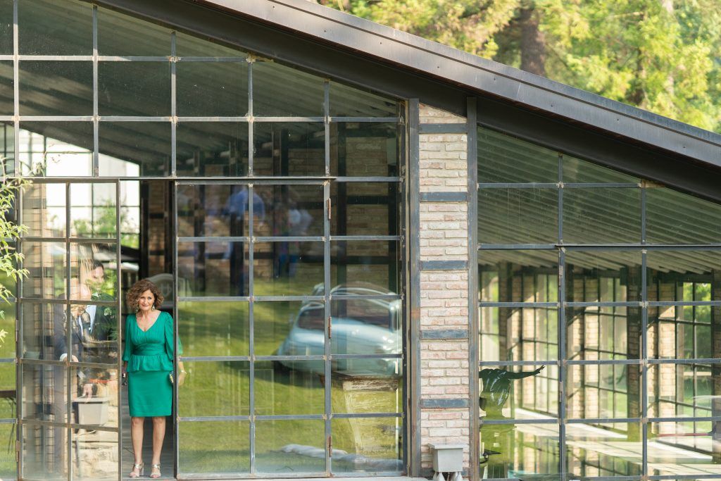 Modern glass building exterior with multiple window panels reflecting natural surroundings.