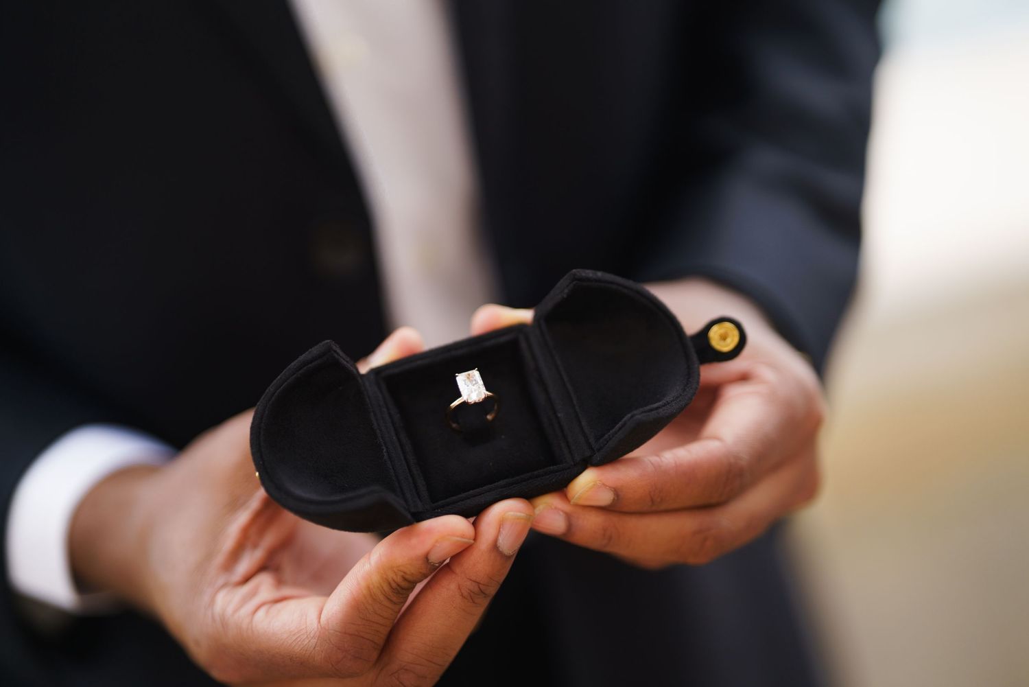 Close-up of hands exchanging or passing a small black object between them.