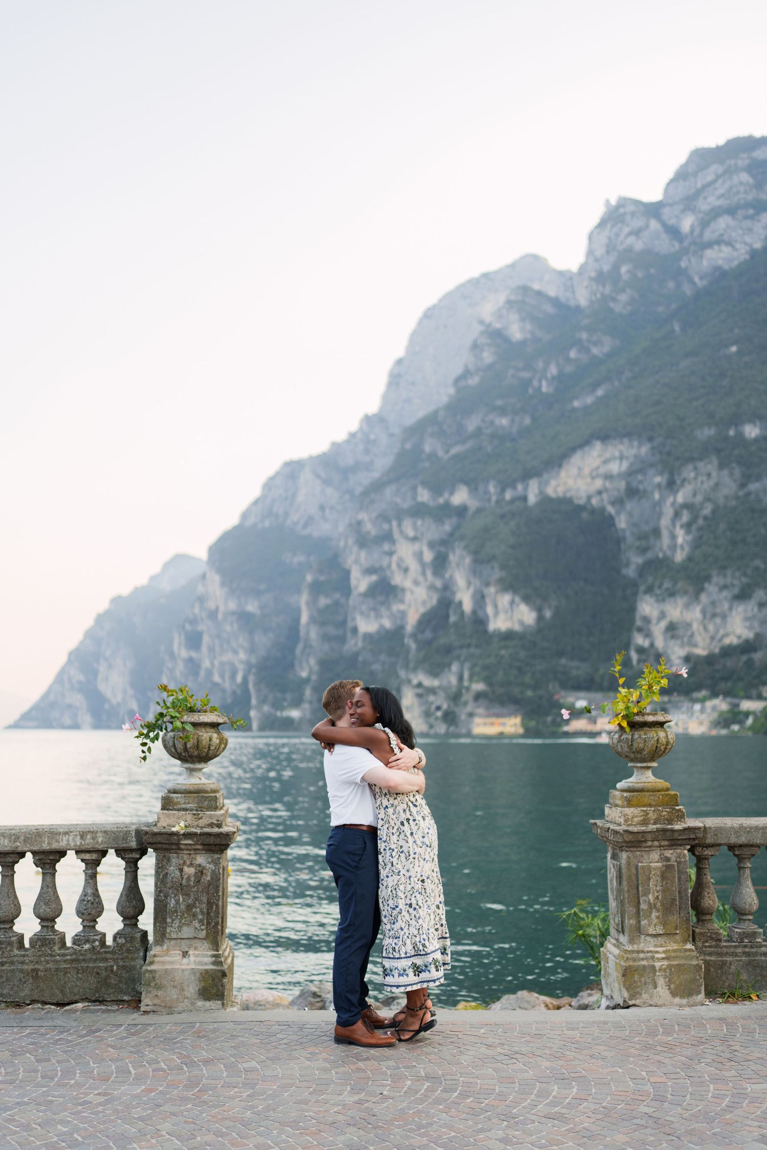 Couple walking together along the waterfront after their proposal in Riva del Garda
