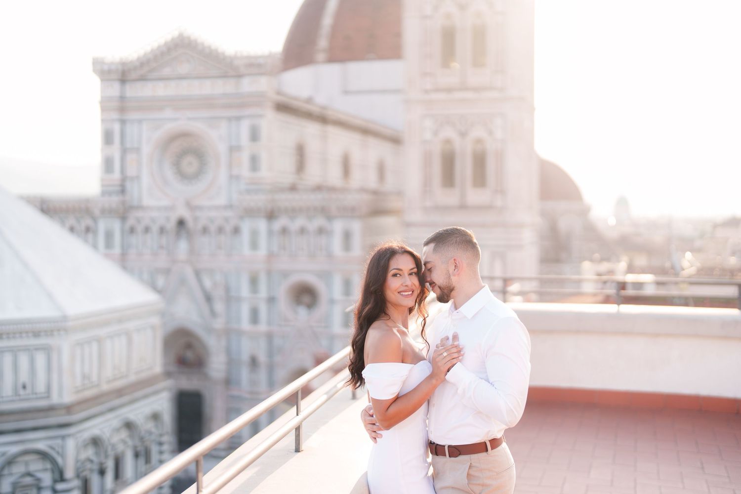 Romantic couple poses for wedding photos in front of Florence Cathedral during golden hour in Italy.