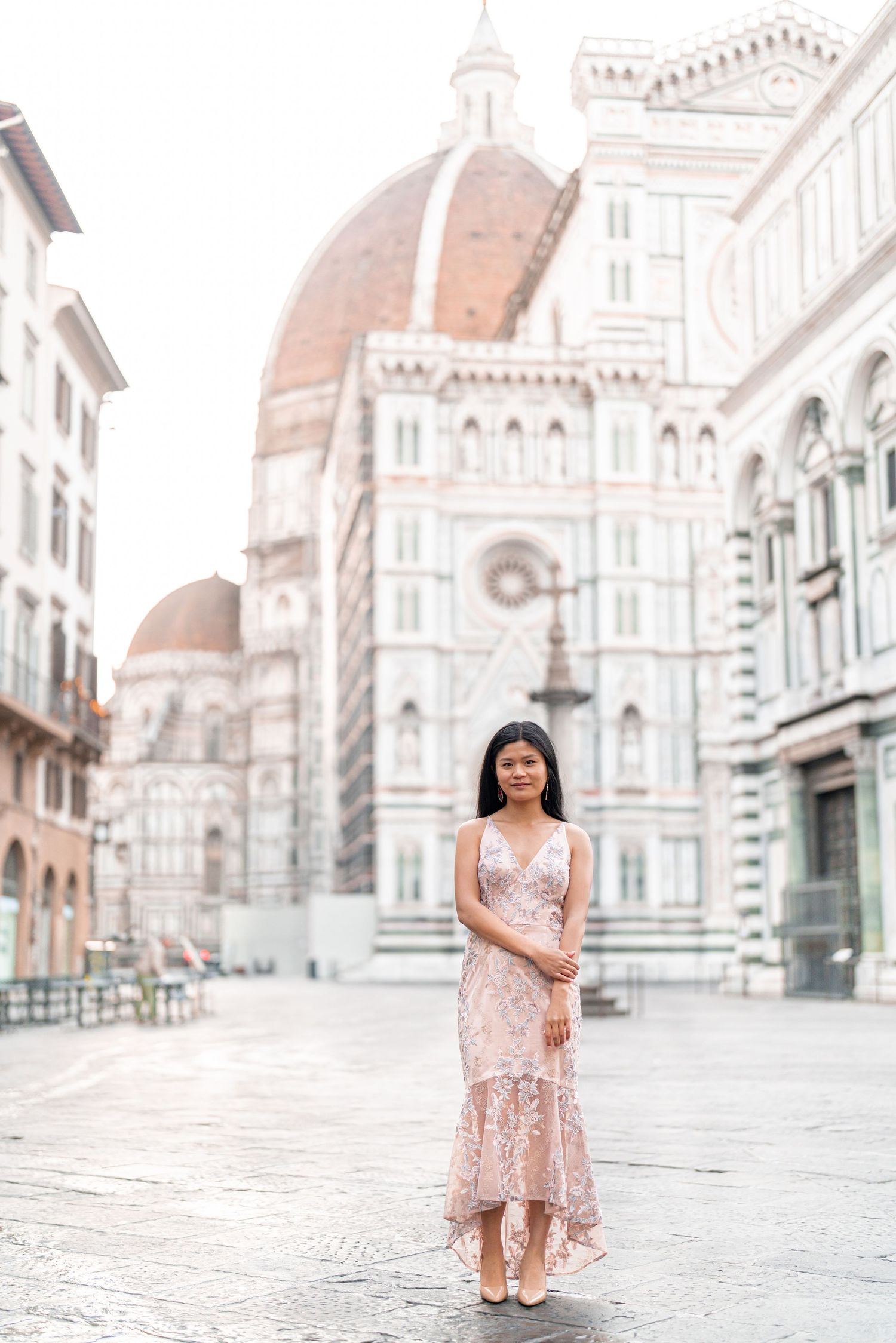 A pink dress against the stunning backdrop of Florence's Duomo cathedral and historic architecture in Italy.