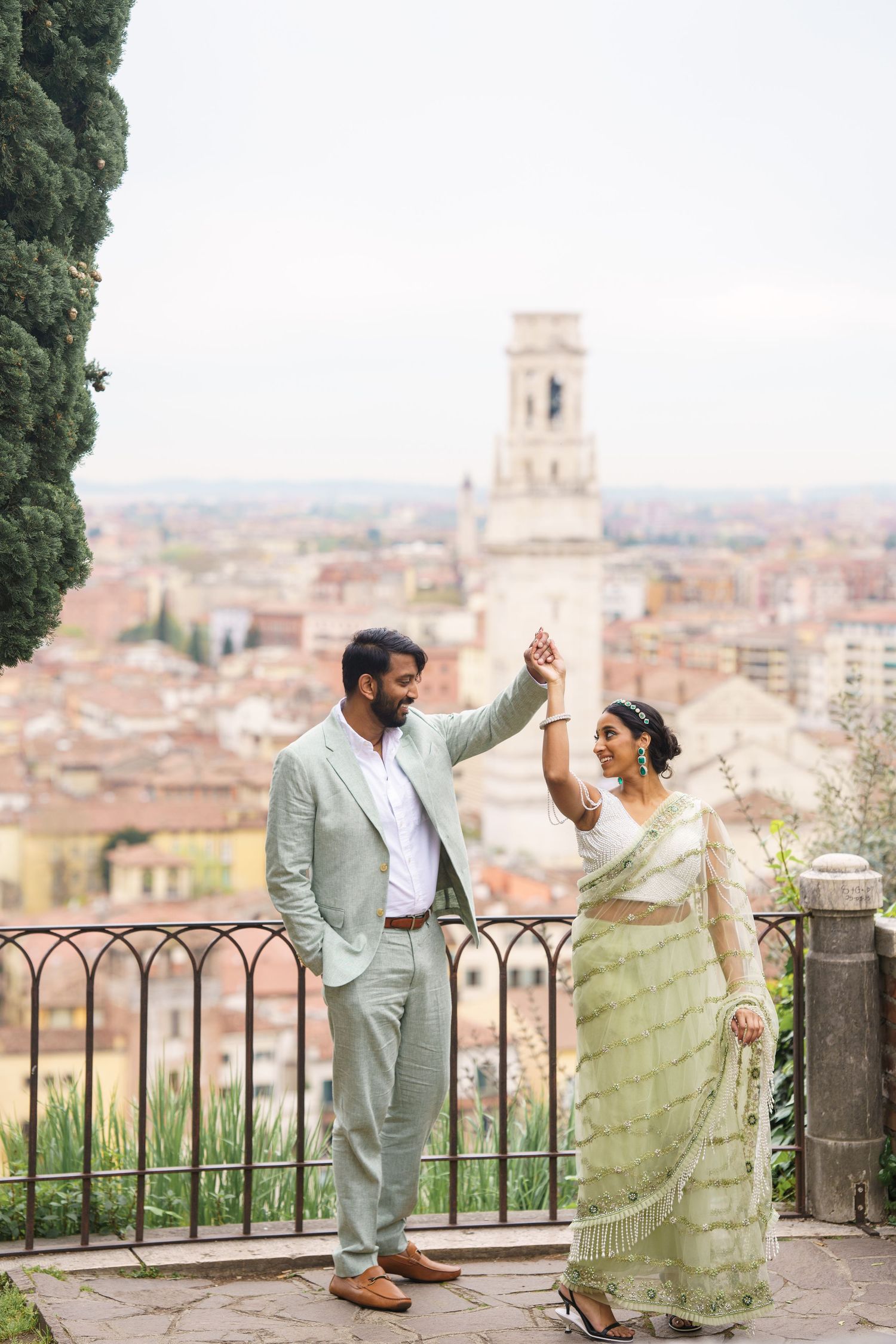 A couple shares a romantic moment overlooking the historic cityscape of Florence, Italy from a scenic viewpoint.