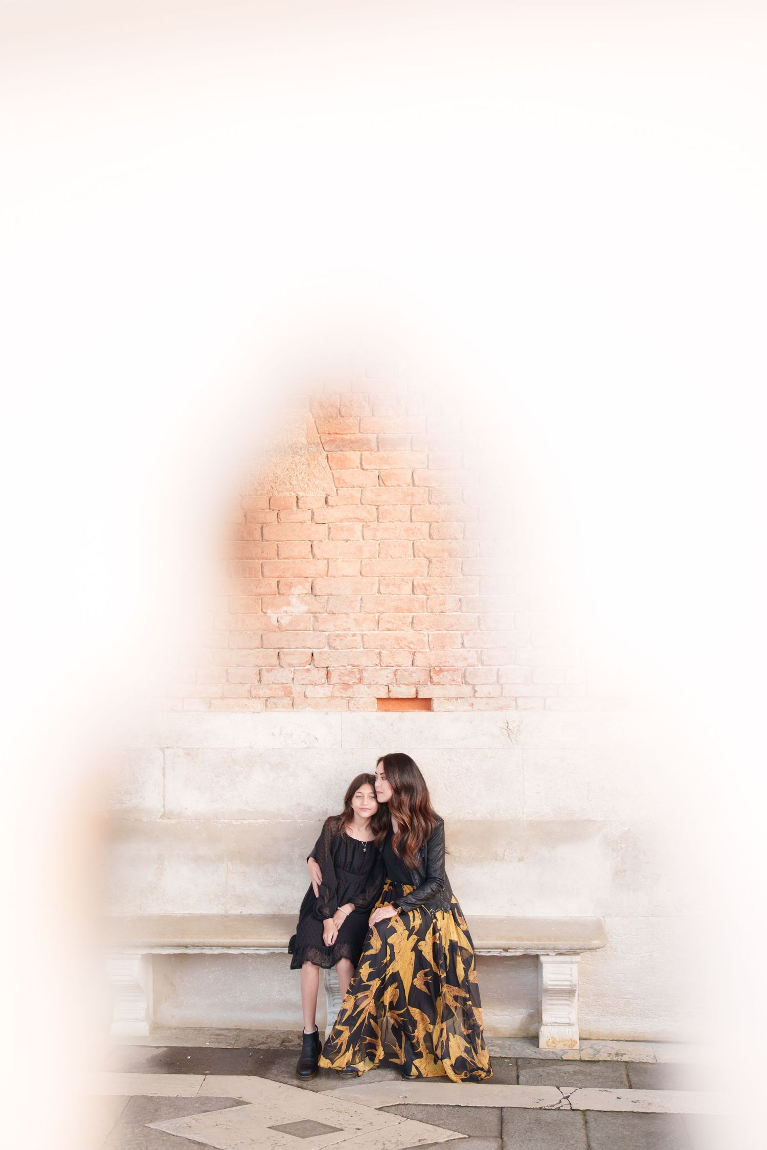 A series of four progressive images showing a couple sitting together on white steps against a brick wall.