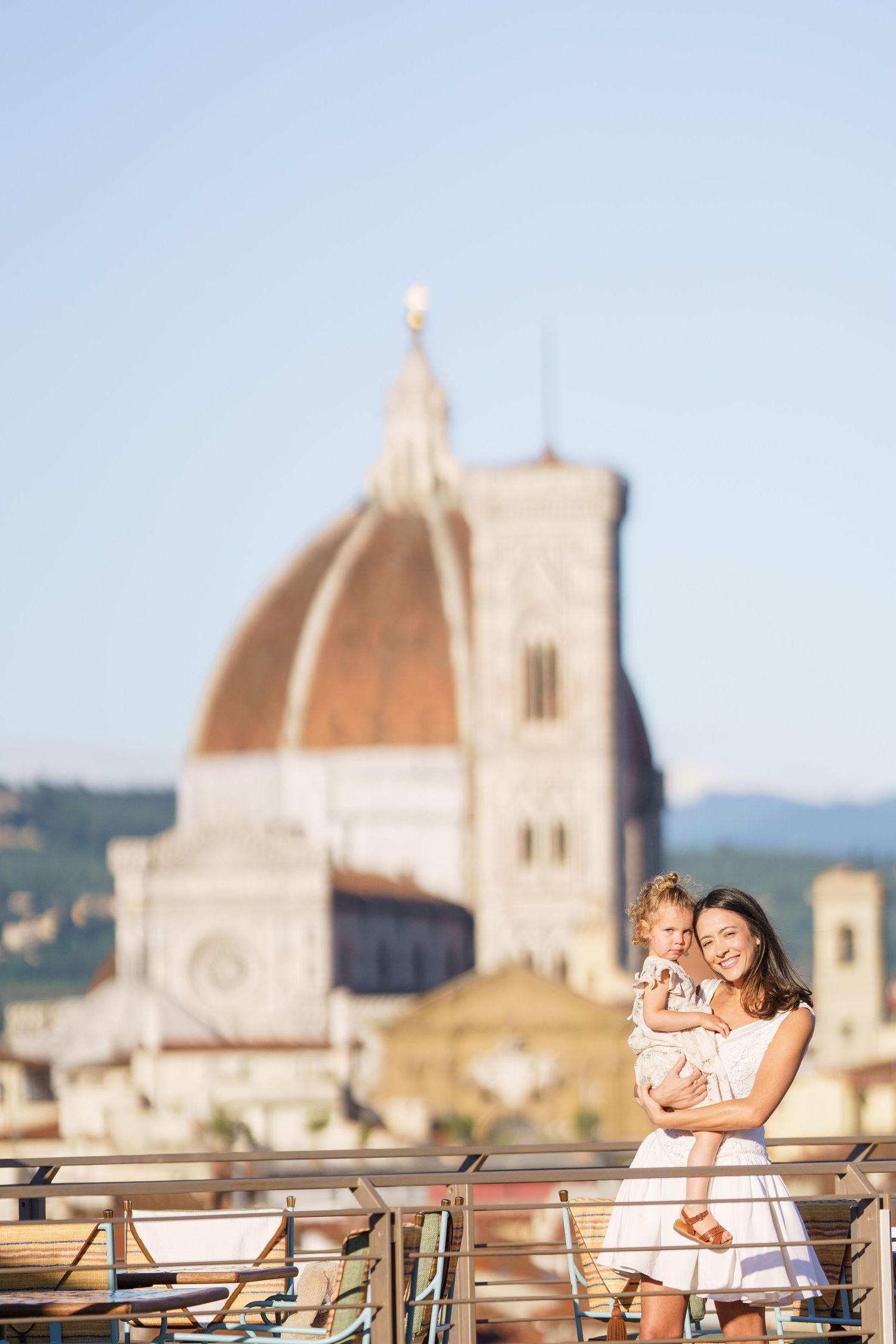 Couple sharing an intimate moment on a terrace overlooking Florence's historic skyline and Duomo.
