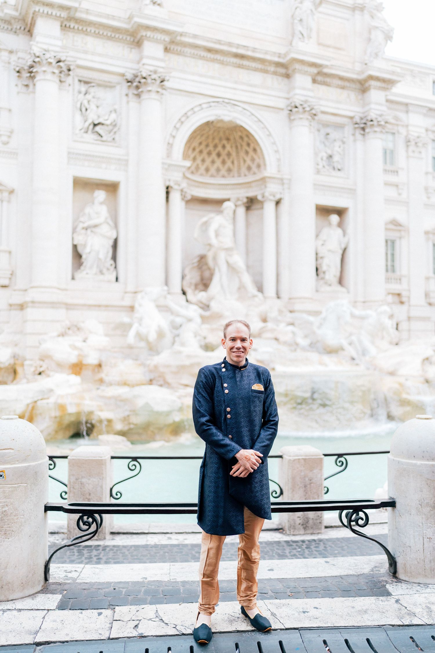Couple posing at the iconic Trevi Fountain in Rome wearing traditional Indian attire.