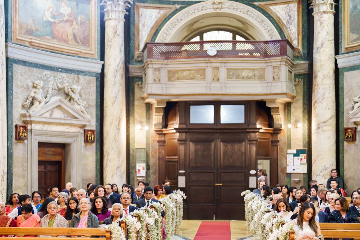 Interior view of a grand church with painted ceilings and classical architecture.