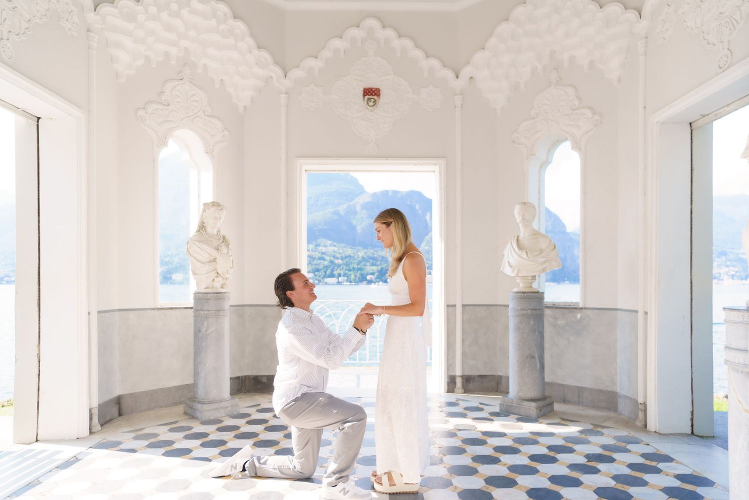 Professional painters in white uniforms applying fresh paint to walls in a bright, spacious room with checkered floors.