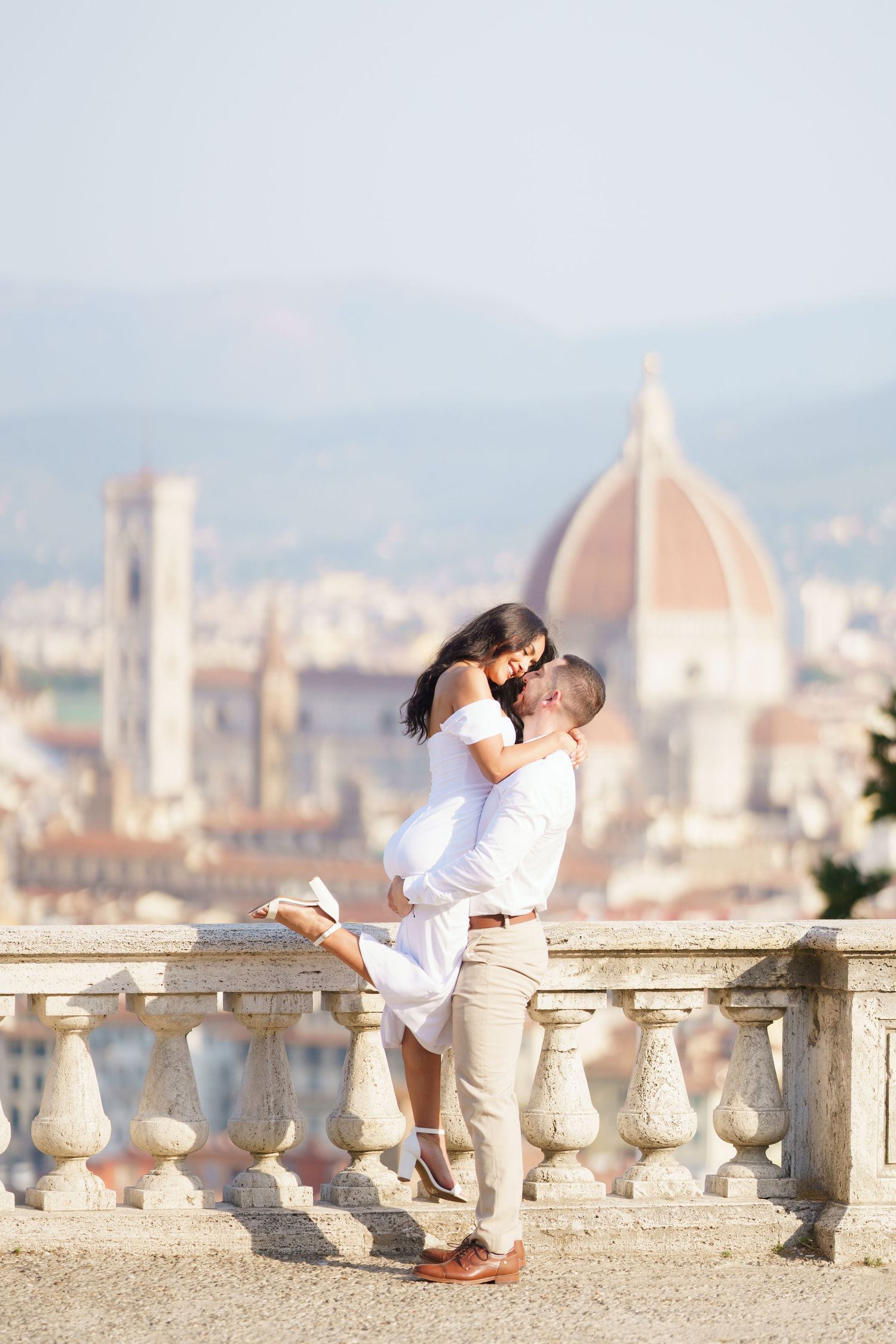A romantic moment captured at Piazzale Michelangelo overlooking Florence's iconic Duomo cathedral in Italy.