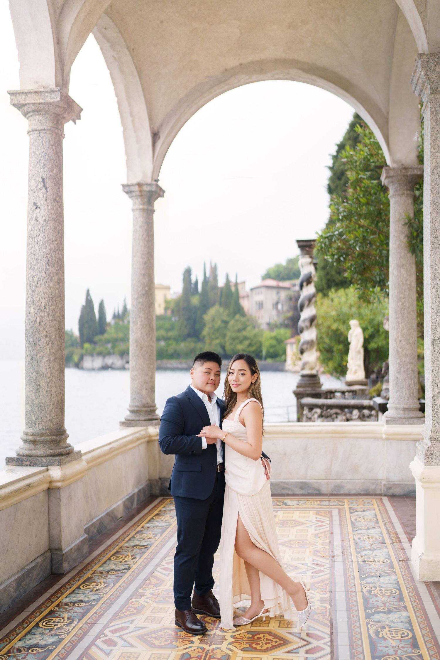 Couple posing elegantly under stone arches at Villa del Balbianello, Lake Como, Italy.