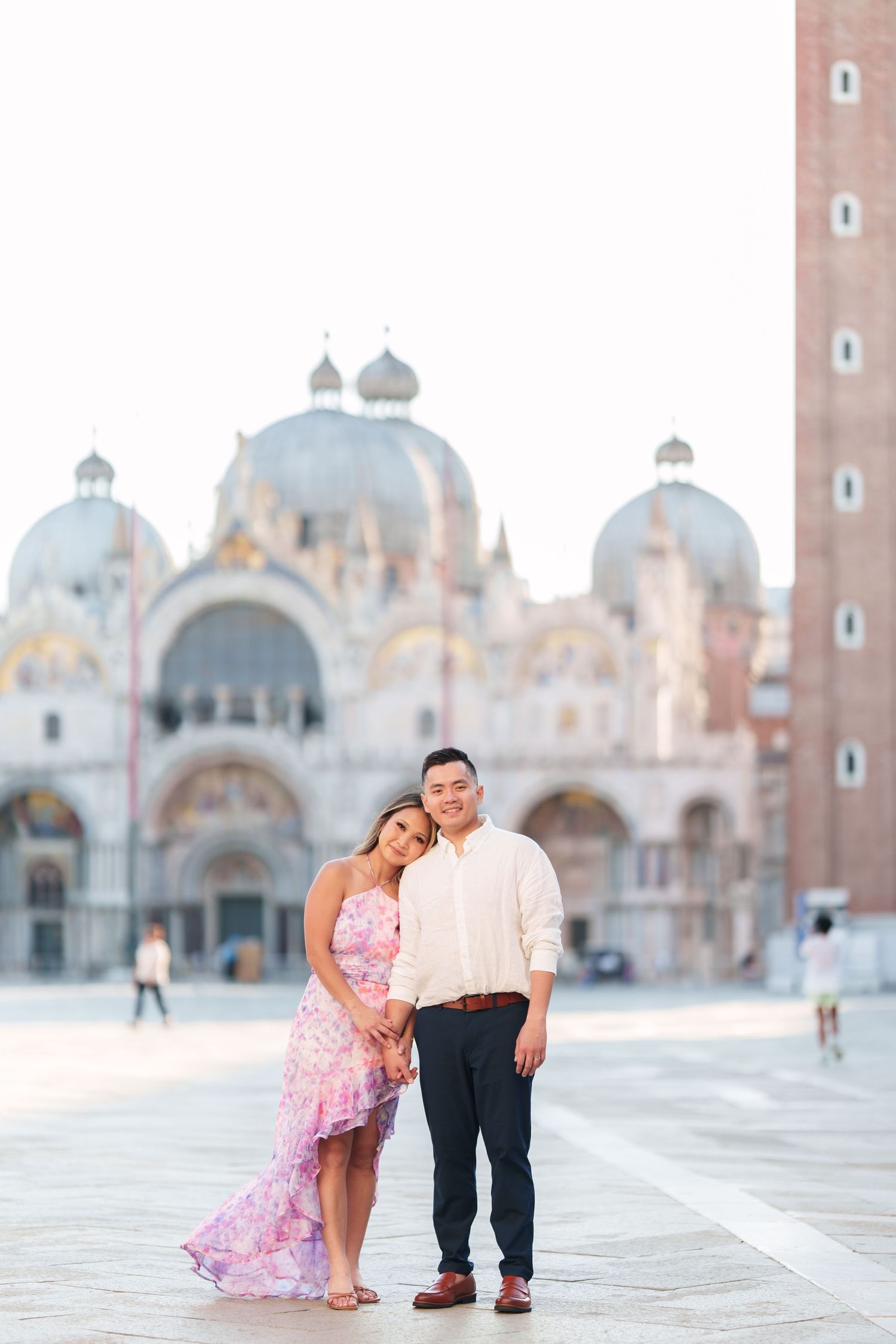 Couple posing in St. Mark's Square, Venice, with the iconic Basilica and Campanile in the background.