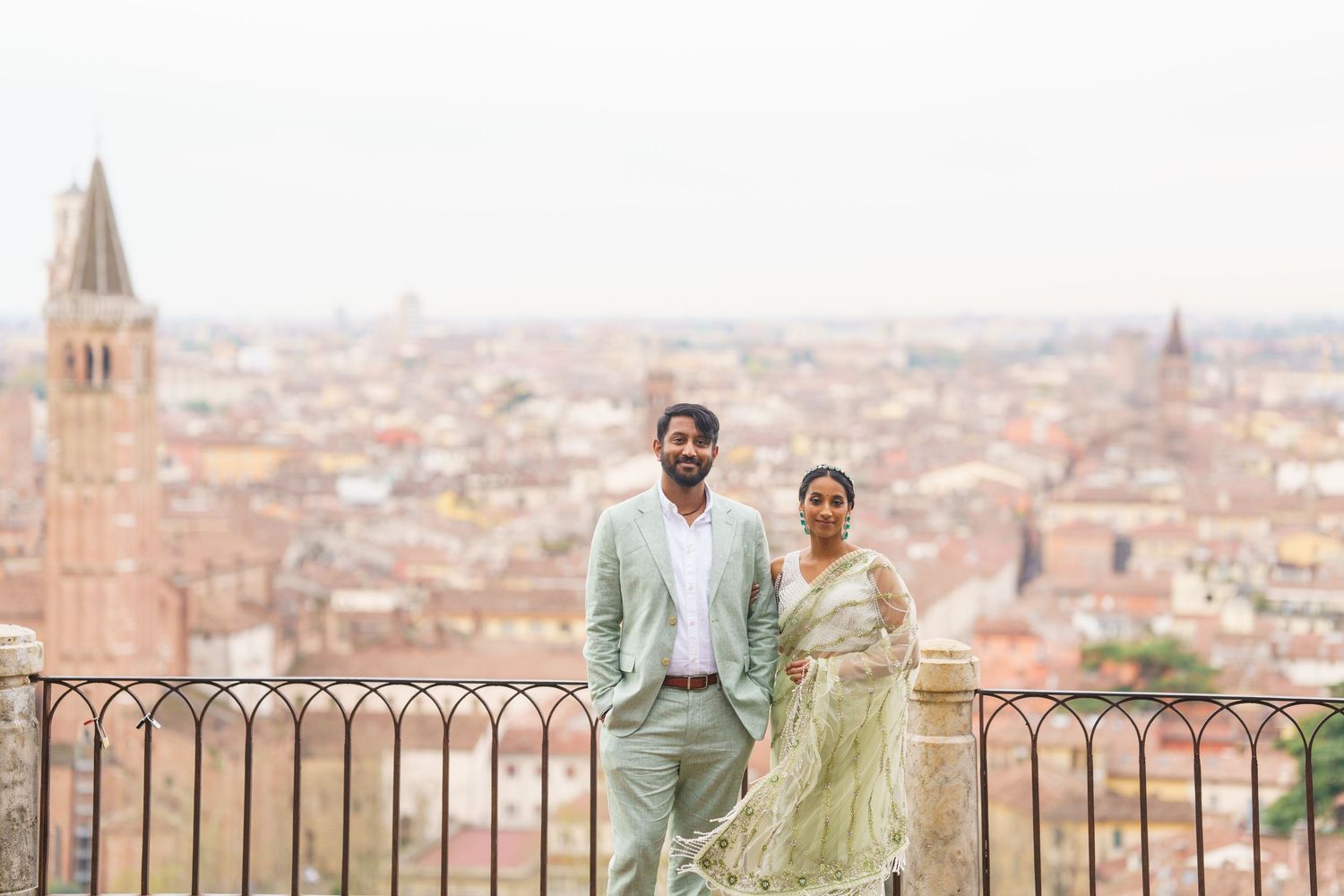 Two people stand at an overlook with a scenic view of Florence, Italy with its historic architecture and terracotta rooftops.