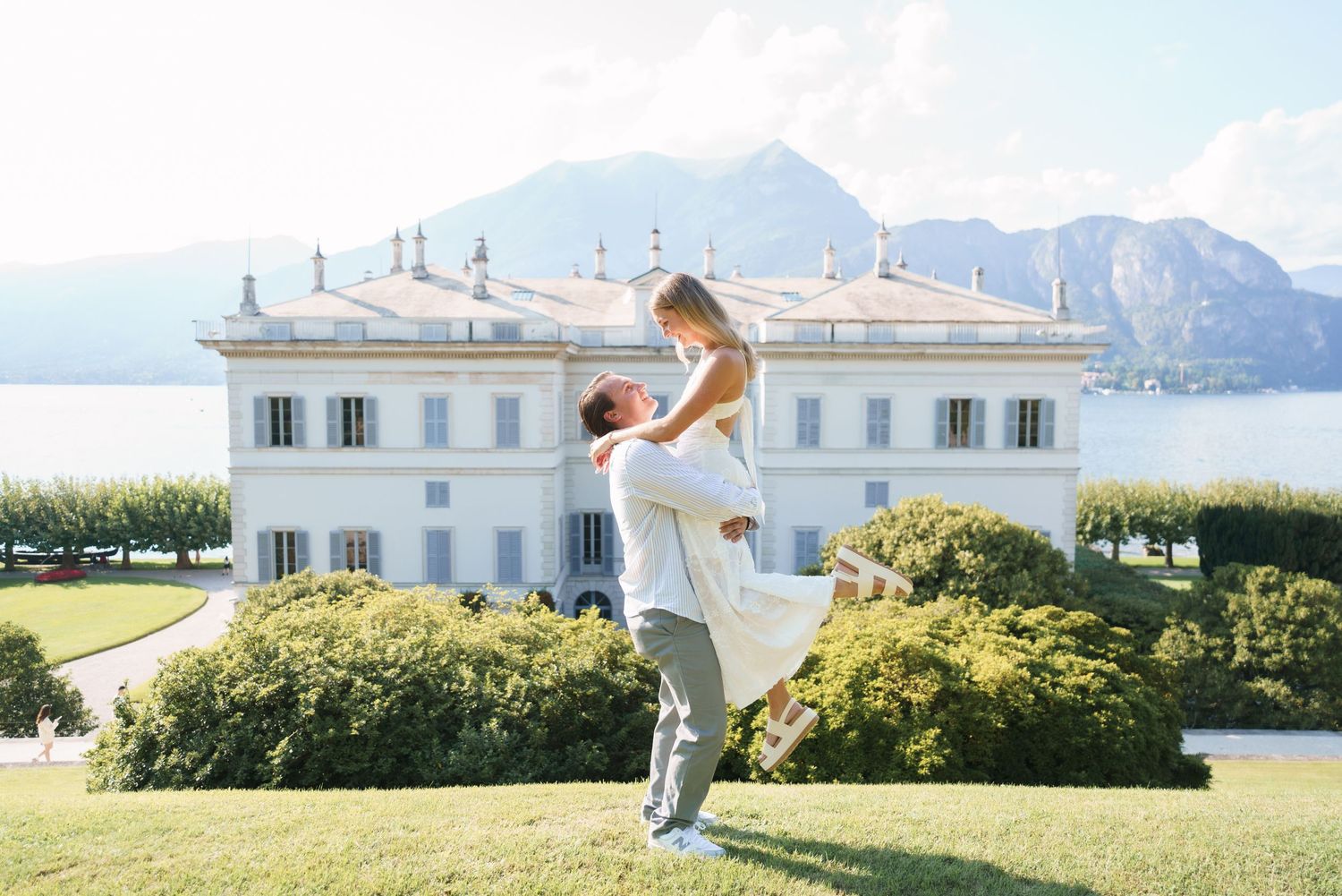 A romantic moment captured in front of a white villa overlooking mountains and lake in Italy.