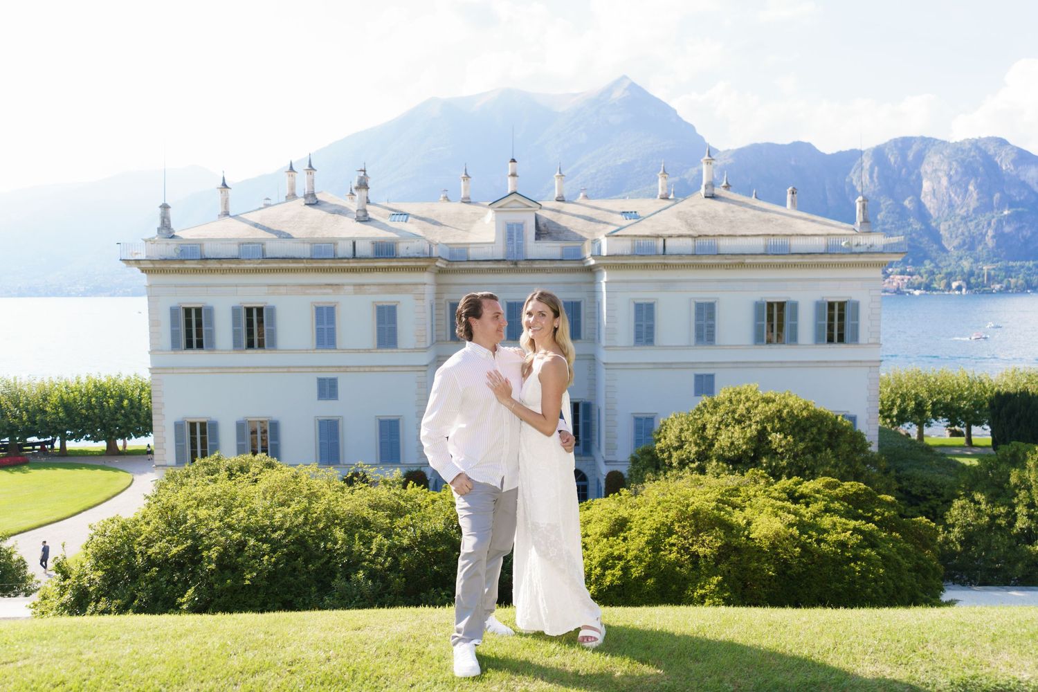 Elegant white villa overlooking Mediterranean coastline with mountain views and manicured gardens.