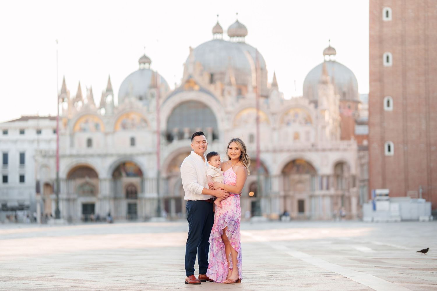 Family portrait in St. Mark's Square, Venice, with the iconic Basilica di San Marco in the golden morning light.