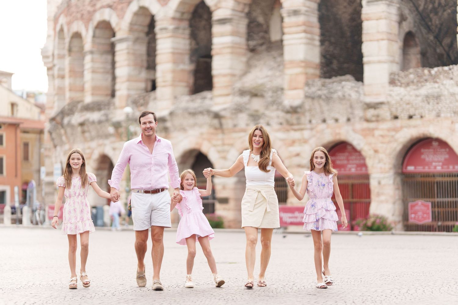 Verona family photographer family walking in front of Verona Arena Italy