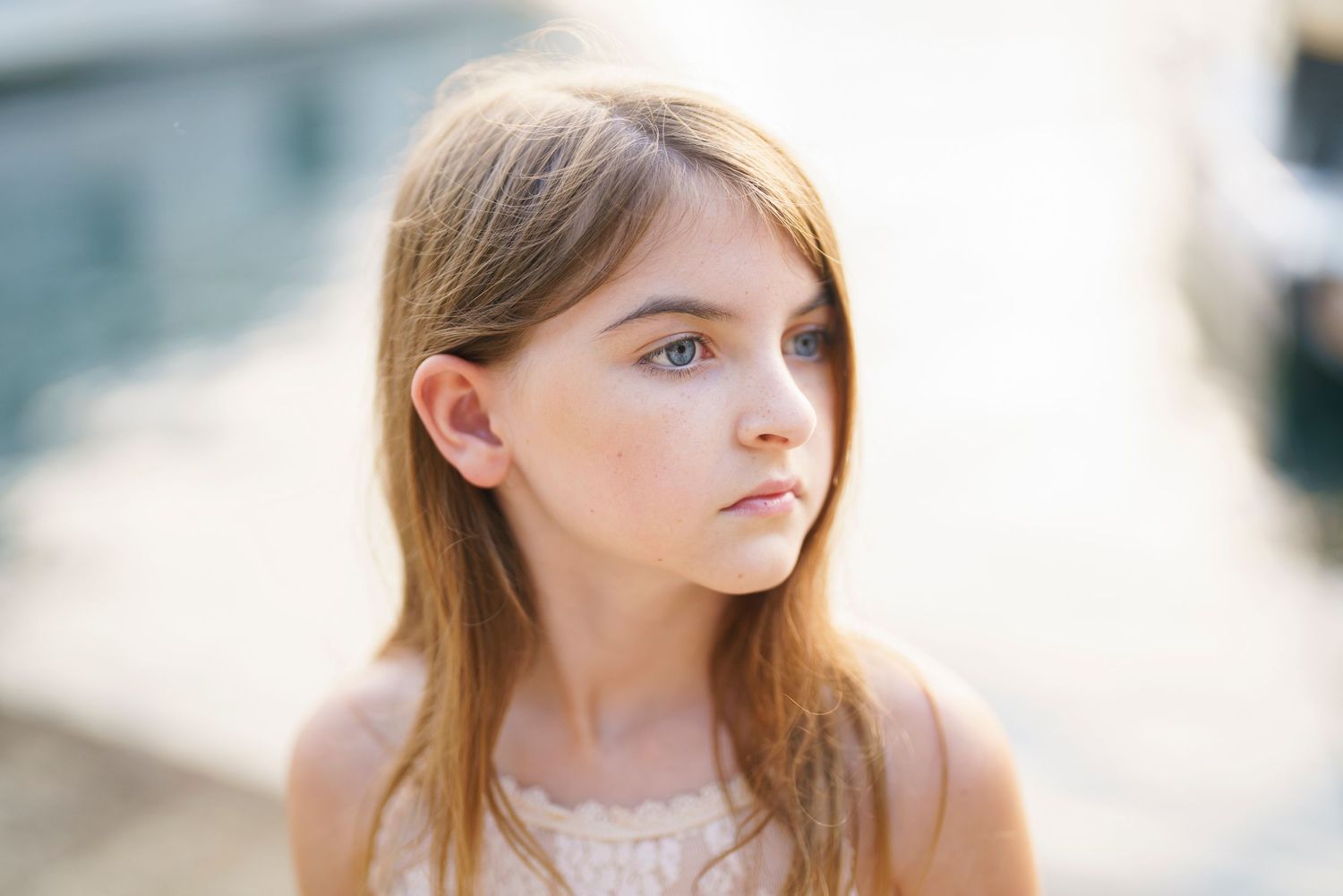 A person with blonde hair gazes to the side in a series of soft, dreamy portraits with natural lighting.