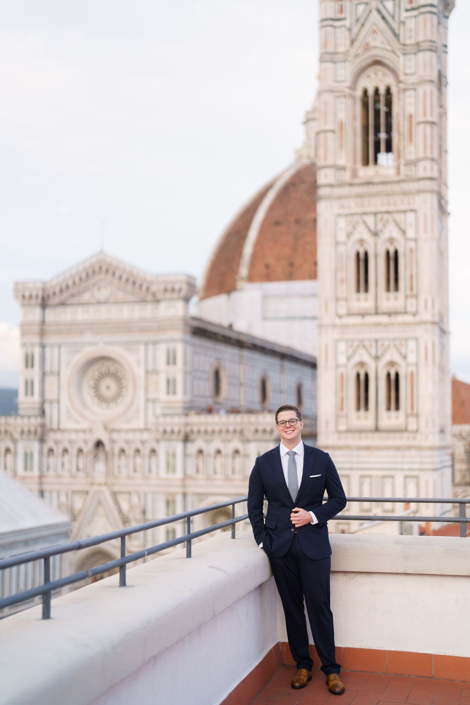Architectural details of Florence's Duomo cathedral with ornate Gothic spires and terracotta rooftops in the background.