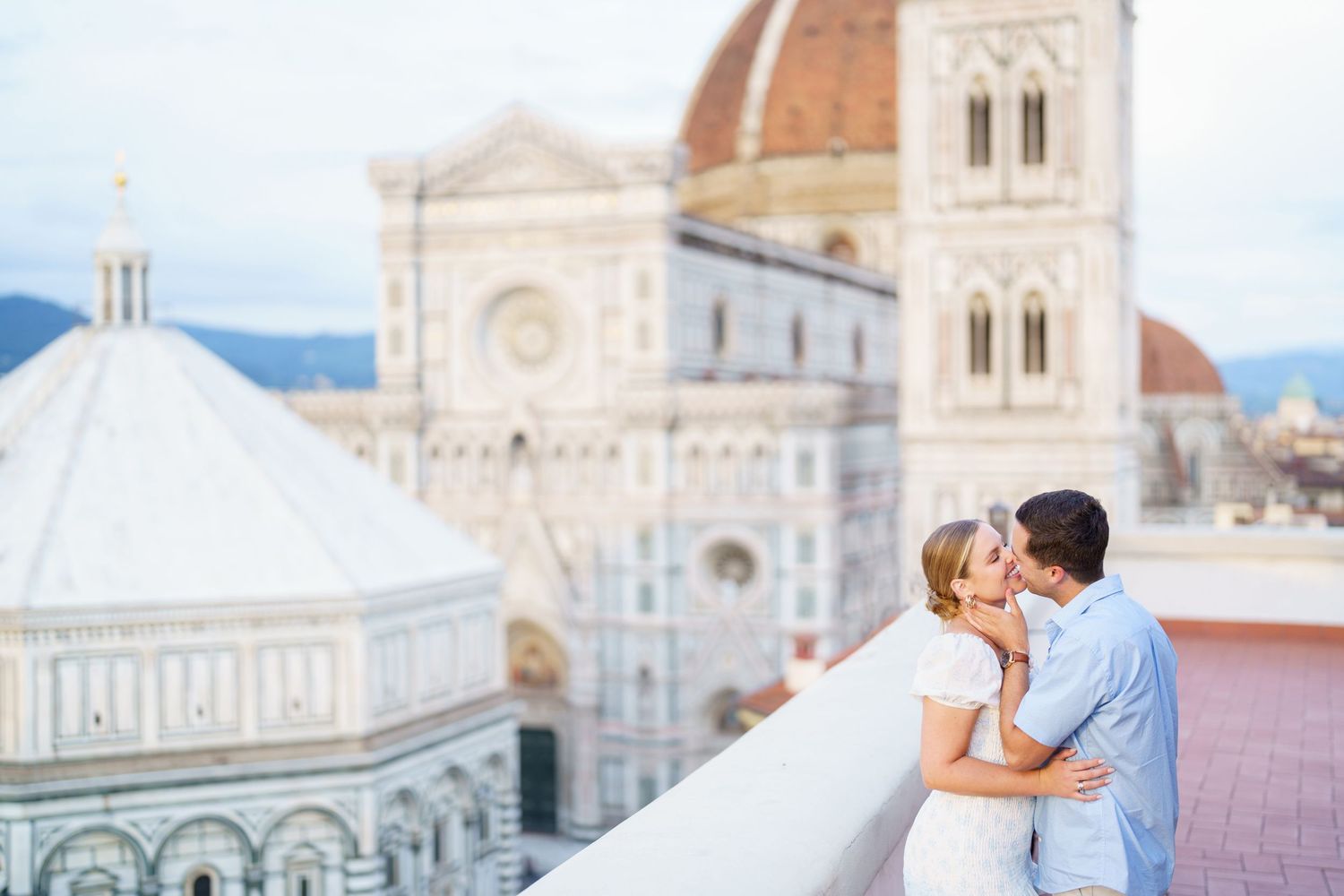 A couple shares a romantic moment in front of Florence Cathedral and Duomo in Italy during sunset.