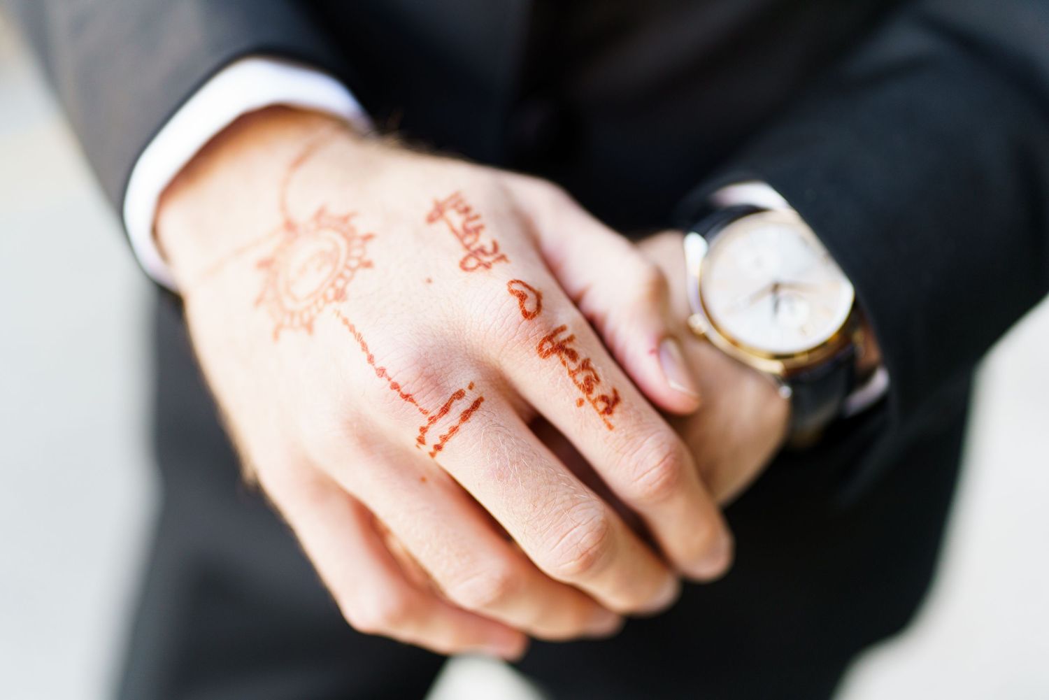 Close-up details of wedding rings and hands showing intricate jewelry.