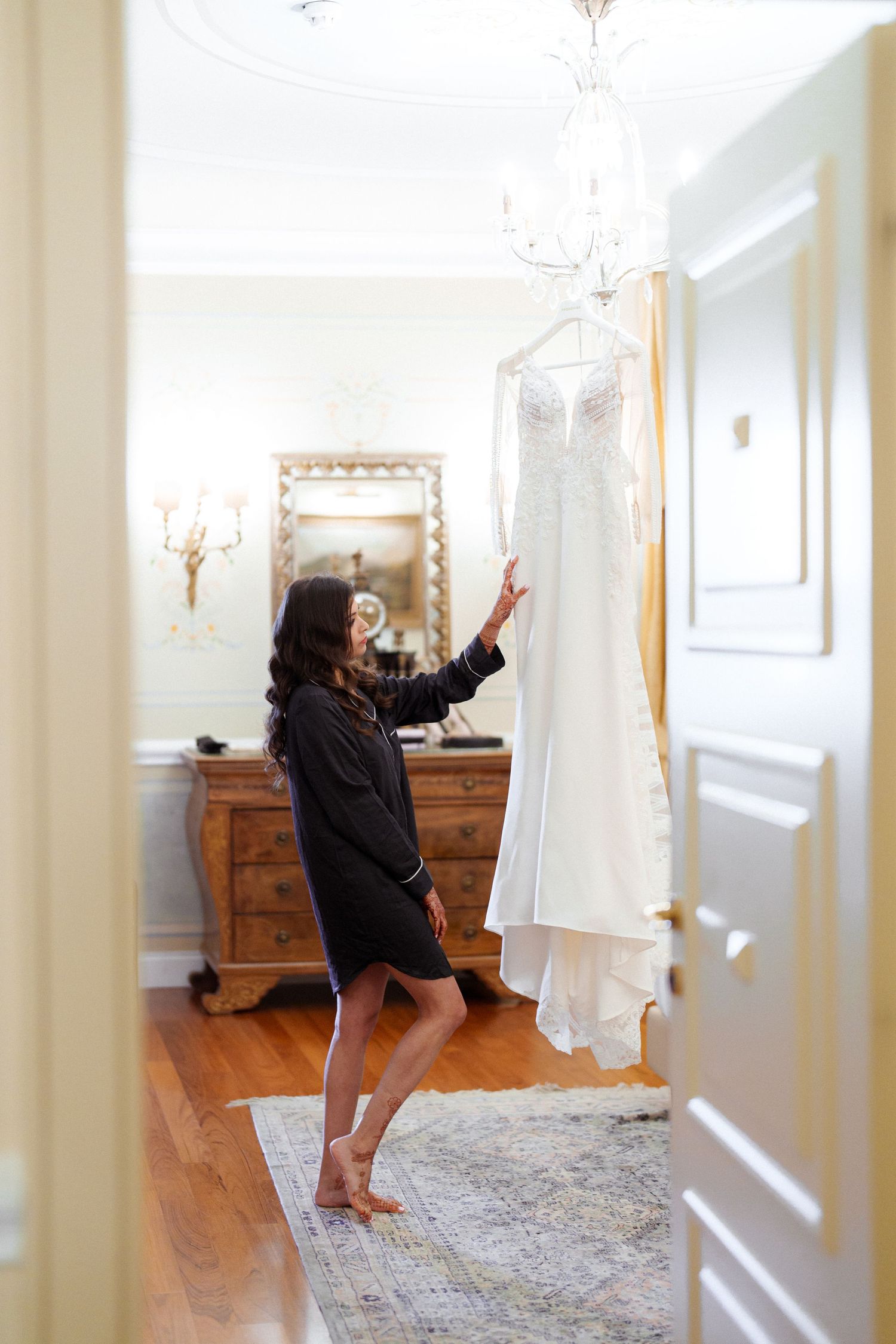 Dancing and twirling in a bright, luxurious bedroom with hardwood floors and crystal chandelier.