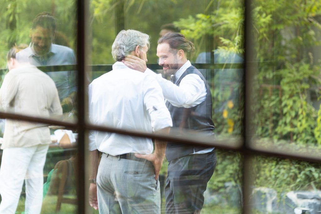 Wedding guests mingle and chat during an outdoor garden reception.