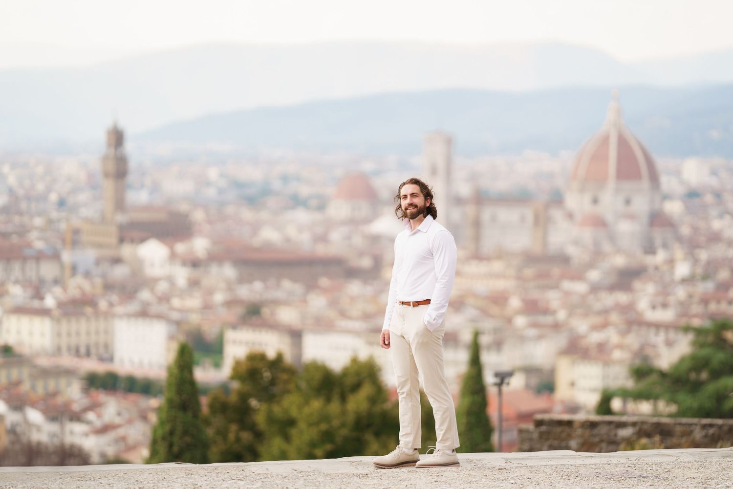 A scenic panoramic view of Florence, Italy with the iconic Duomo cathedral dome rising above the cityscape.