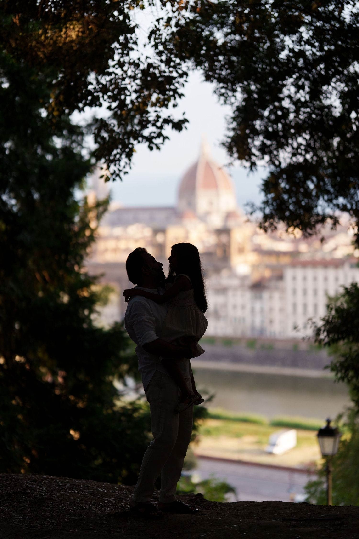 Romantic couple silhouette embracing at dusk with Florence Cathedral dome in background, Italy.