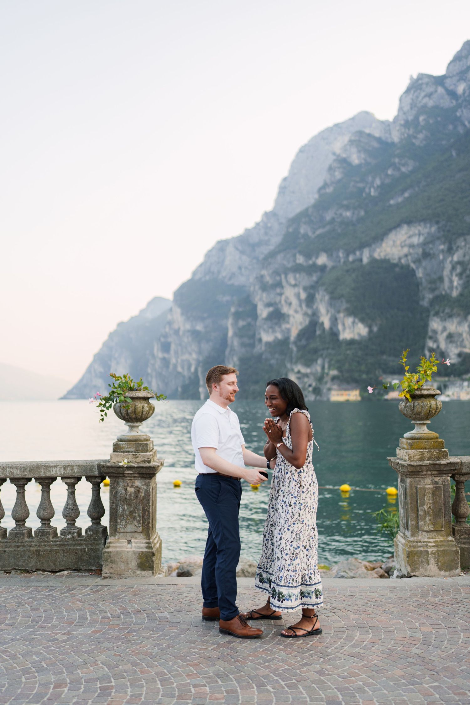 Engaged couple embracing beside Lake Garda during their Riva del Garda proposal session