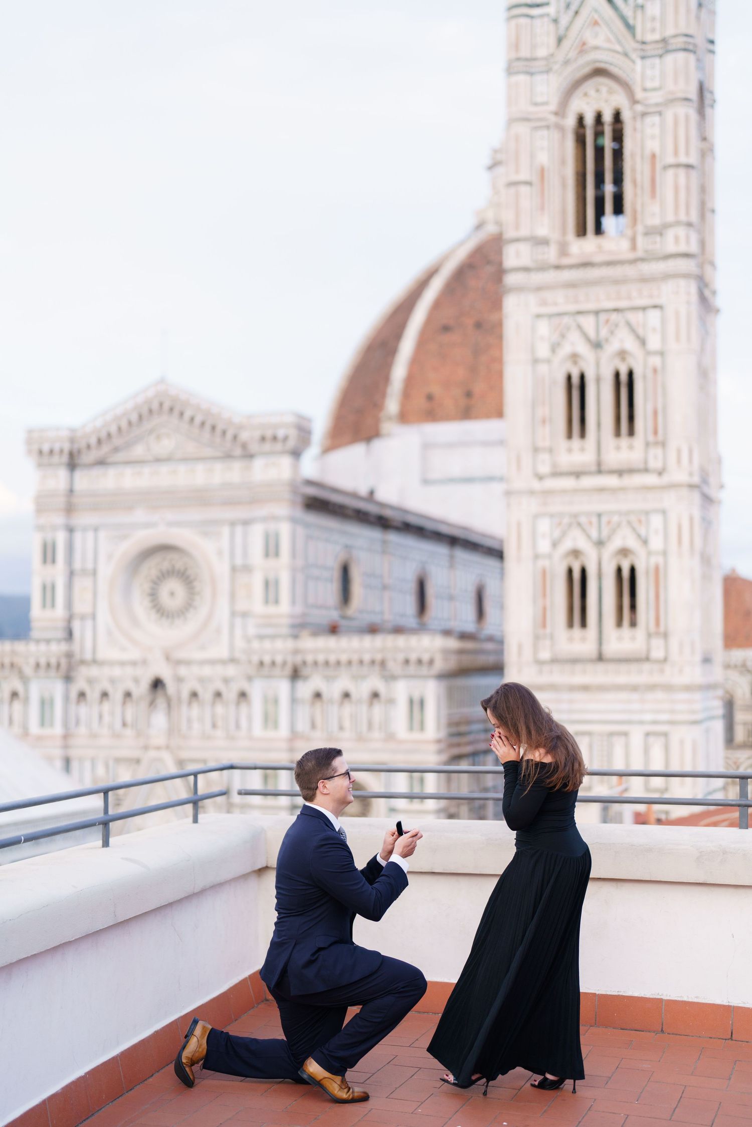 A romantic proposal moment captured in a series of photos on a rooftop terrace with Florence Cathedral in the background.