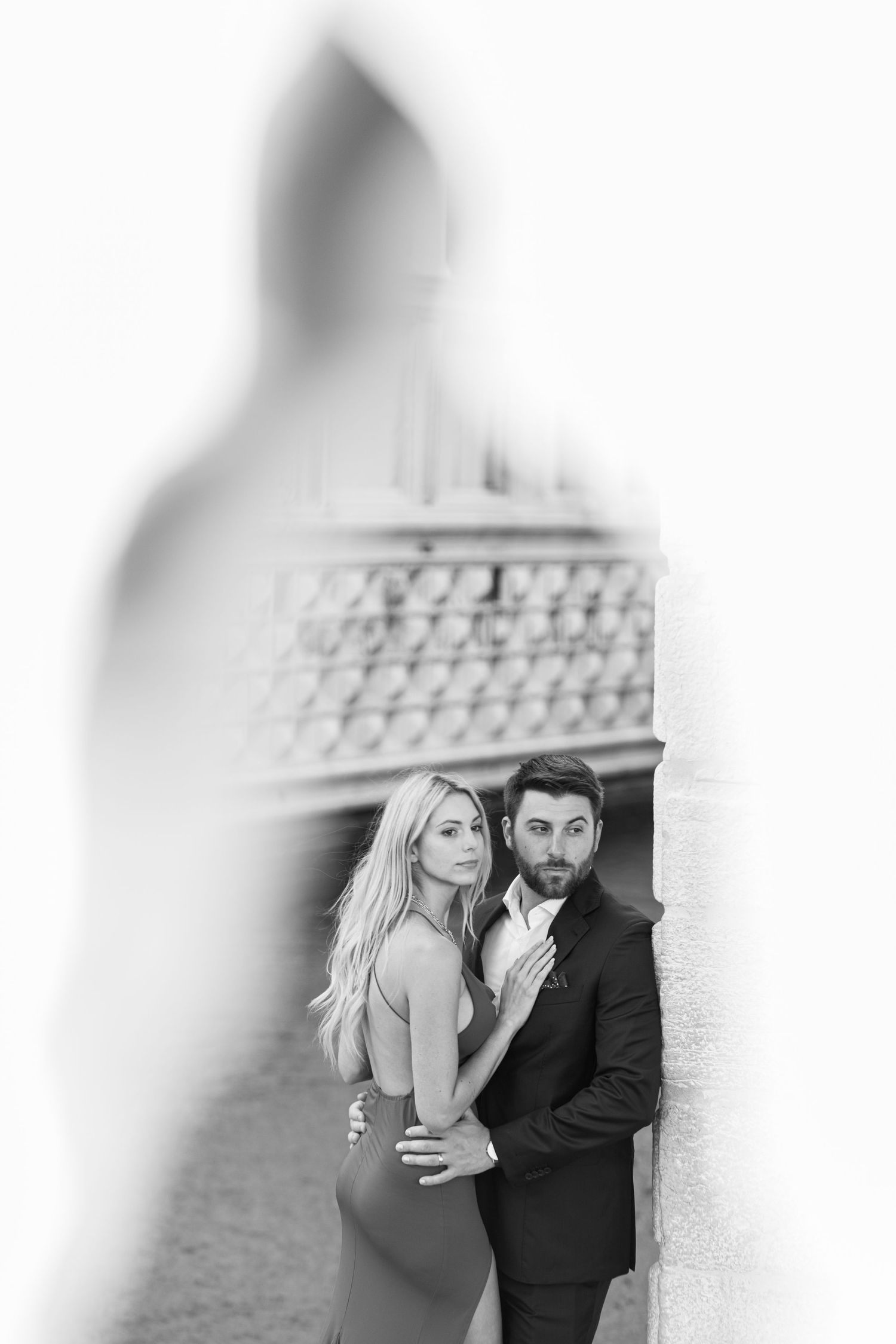 A romantic black and white photo series showing a couple embracing and sharing intimate moments outdoors.