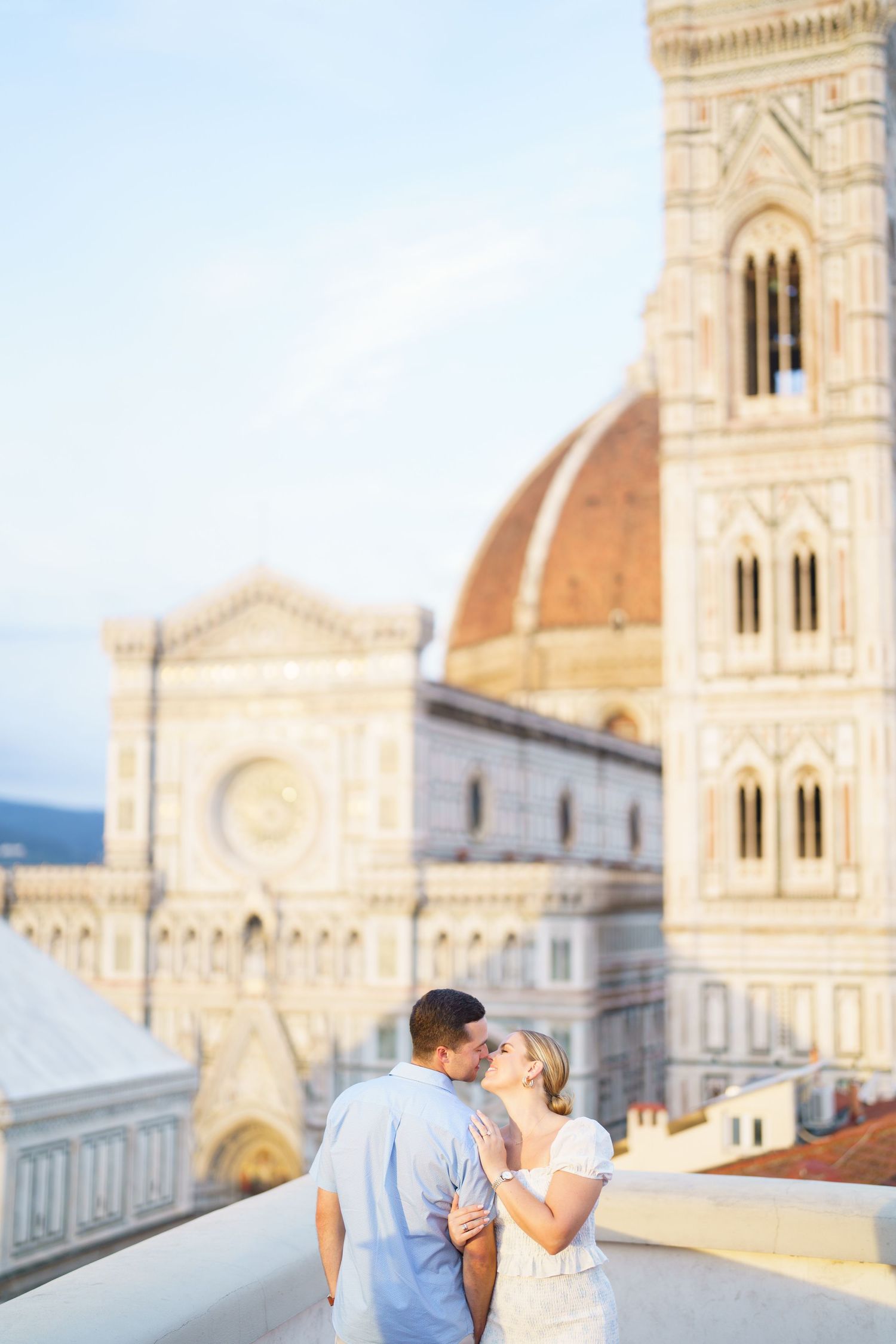 Romantic couple embracing near the historic Duomo cathedral in Florence, Italy during sunset.