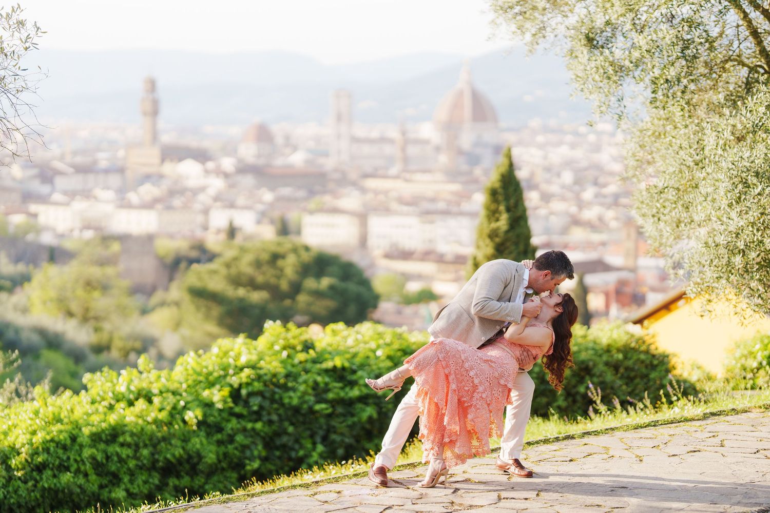 A person in athletic wear stretches on a hilltop overlooking Florence, Italy with the Duomo cathedral visible in the distance.