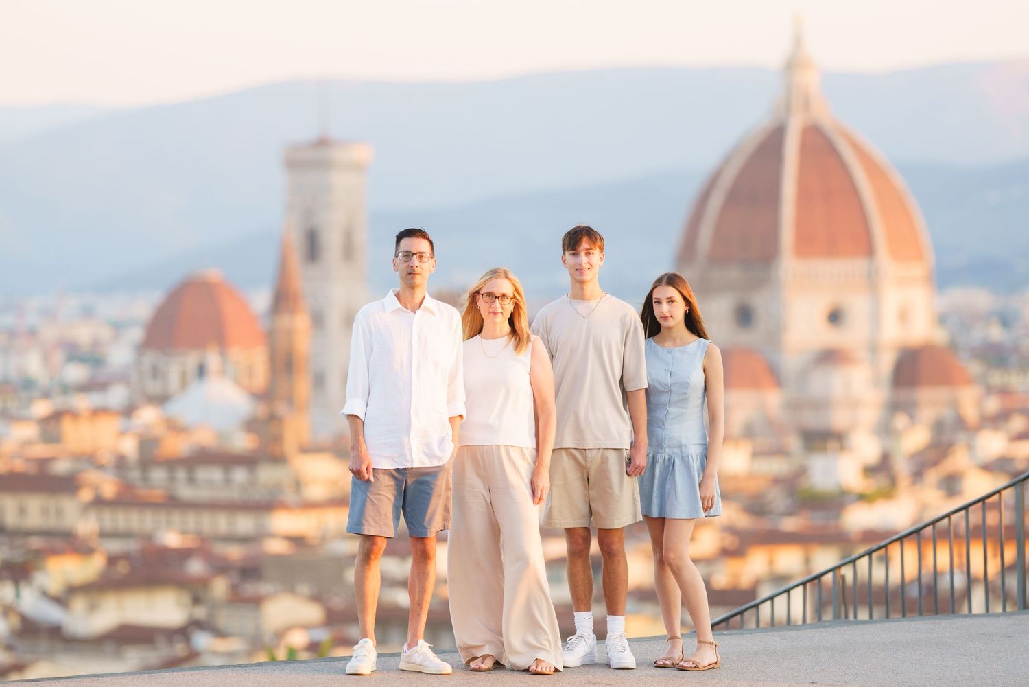 Family portrait session with Florence Cathedral's iconic dome in the background during golden hour in Italy.