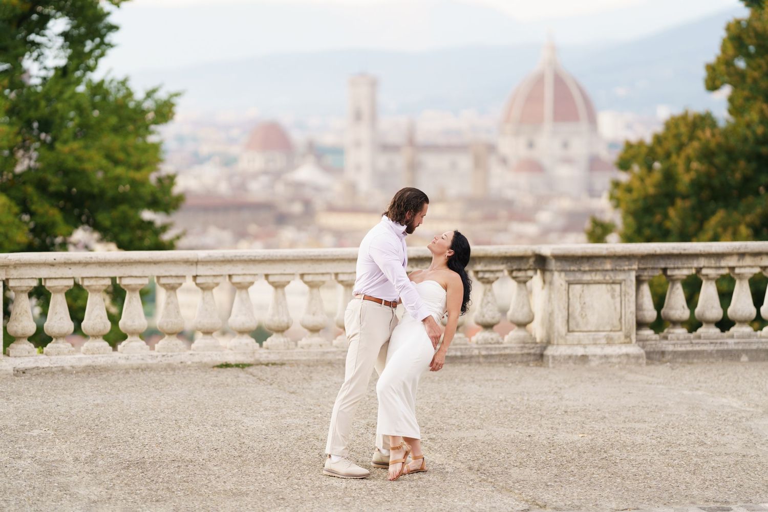 A romantic moment overlooking the iconic Duomo cathedral and skyline of Florence, Italy from Piazzale Michelangelo.