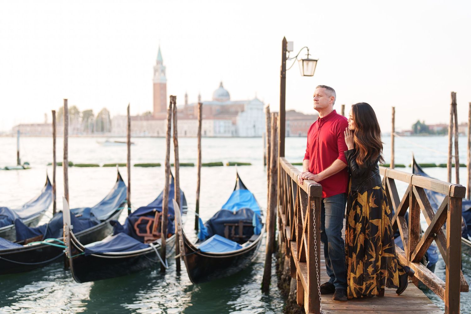 photographer venice Couple admiring traditional gondolas and view of San Giorgio Maggiore church across Venice lagoon at sunset.