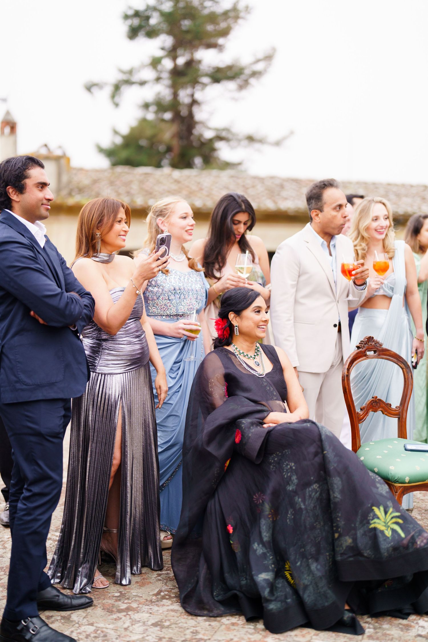Wedding guests seated in formal attire at an outdoor celebration.