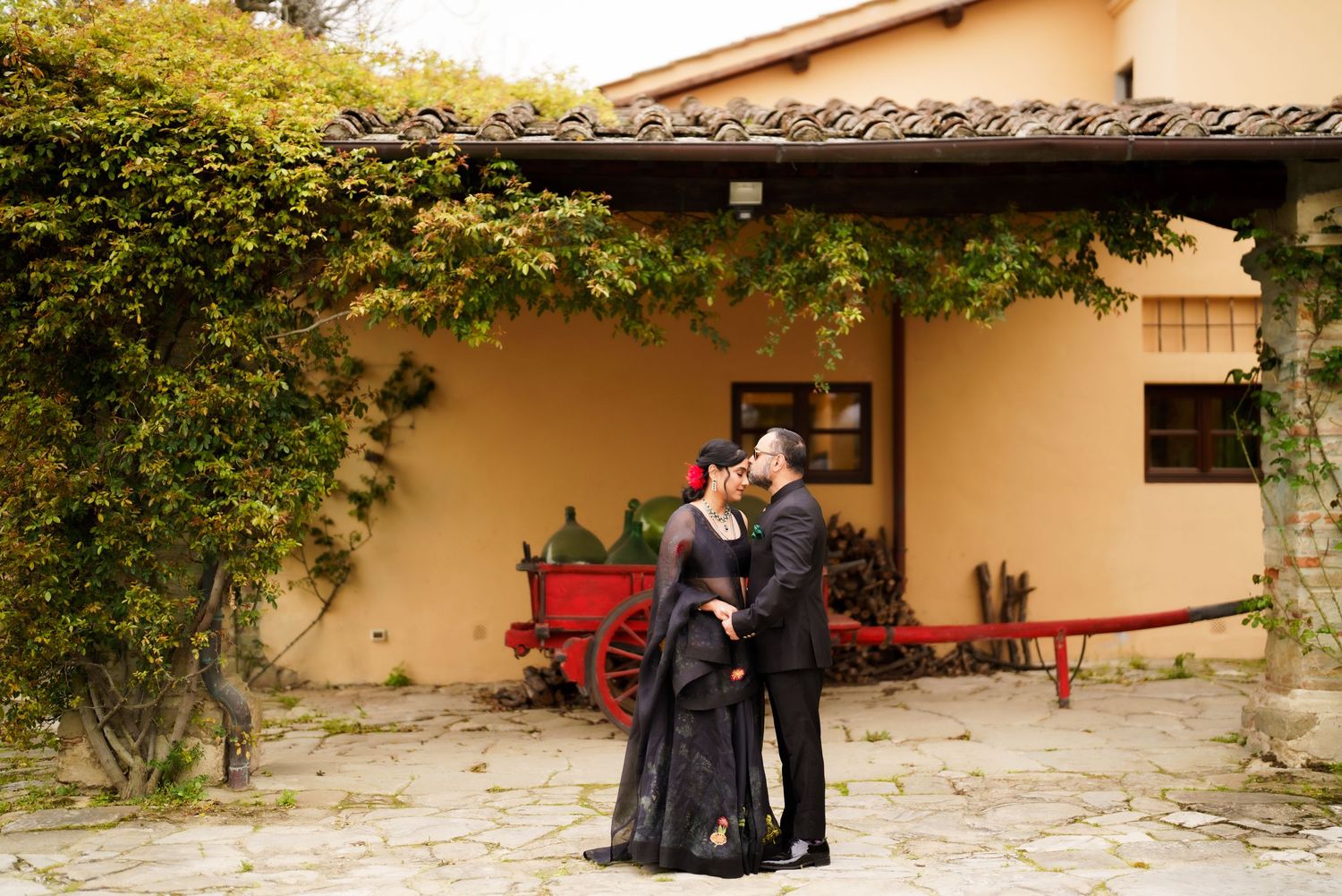 Stone courtyard with climbing vines and red bench creating romantic outdoor setting.