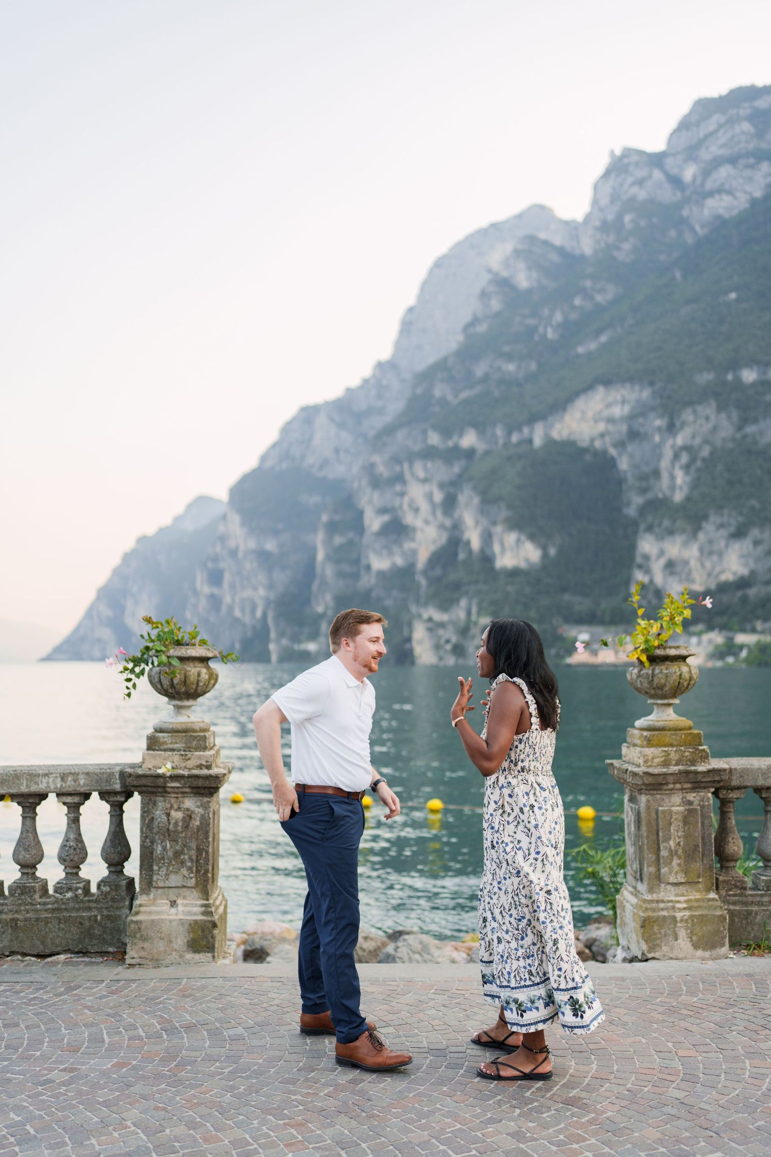 Engaged couple embracing beside Lake Garda during their Riva del Garda proposal session