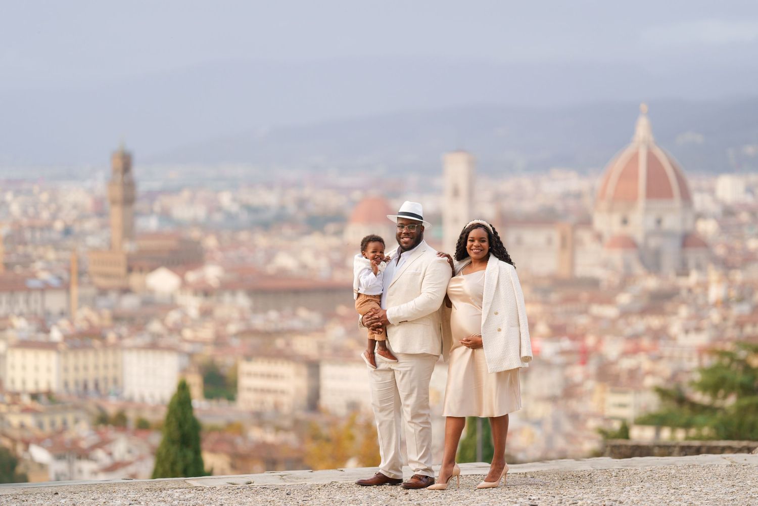 Family posing with Florence skyline and Duomo cathedral backdrop in Italy.